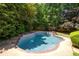 Backyard with in-ground pool, brick-lined patio, and surrounding trees at 6275 Cheatham Lake Nw Dr, Acworth, GA 30101