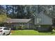 Charming two-story home with a basketball hoop on the garage, neutral siding, and mature trees at 4287 Ridgetop Trl, Ellenwood, GA 30294