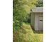 Side yard of the house with a pathway, lush greenery, and a view of the surrounding wooded area at 4287 Ridgetop Trl, Ellenwood, GA 30294
