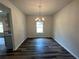 Dining room with wood flooring, modern chandelier, neutral walls and ample light from window at 142 Tye St, Stockbridge, GA 30281
