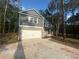 Charming two-story home with a gray siding, brick accents, and a two-car garage with ample treed front yard at 142 Tye St, Stockbridge, GA 30281