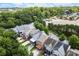 An aerial view of modern townhouses with decks, driveways, and mature trees near a parking lot and distant cityscape at 1744 Habershal Nw Dr, Atlanta, GA 30318