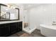 Bathroom featuring a walk-in shower, soaking tub, black vanity, and subway tile at 1744 Habershal Nw Dr, Atlanta, GA 30318