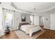 Bright bedroom featuring hardwood floors, tray ceiling, and natural light from the window at 1744 Habershal Nw Dr, Atlanta, GA 30318