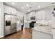 Bright kitchen with stainless steel refrigerator, granite countertops, and white cabinetry at 1744 Habershal Nw Dr, Atlanta, GA 30318