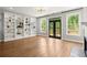 Bright living room with hardwood floors, built-in bookshelves, and doors leading to a deck at 1744 Habershal Nw Dr, Atlanta, GA 30318