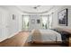 Bright main bedroom featuring a tray ceiling, wood floors, and large windows with natural light at 1744 Habershal Nw Dr, Atlanta, GA 30318