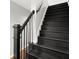 Elegant staircase with black wood treads and black metal railing offering a modern design at 1744 Habershal Nw Dr, Atlanta, GA 30318