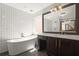 Elegant bathroom featuring a soaking tub, subway tile, modern vanity, and statement mirror, perfect for relaxation at 1744 Habershal Nw Rd, Atlanta, GA 30318