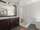 Modern bathroom featuring a glass-enclosed shower, a freestanding tub, and a stylish vanity with gold fixtures at 1744 Habershal Nw Rd, Atlanta, GA 30318