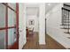 Inviting hallway with hardwood floors and elegant white wainscoting leading to a dining area at 1744 Habershal Nw Rd, Atlanta, GA 30318