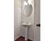 A stylish pedestal sink and an oval mirror grace this bathroom at 5661 Radford Loop, Fairburn, GA 30213