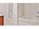 Bright bathroom featuring a soaking tub and a separate glass-enclosed shower at 5661 Radford Loop, Fairburn, GA 30213