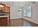 Sunlit dining area featuring hardwood floors and a modern chandelier at 5661 Radford Loop, Fairburn, GA 30213