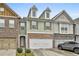 A lovely townhome with a brick and siding exterior, complemented by a spacious two-car garage at 5661 Radford Loop, Fairburn, GA 30213