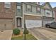 Well-maintained townhouse featuring a two-car garage and neat landscaping at 5661 Radford Loop, Fairburn, GA 30213