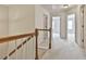 Hallway with neutral carpet and wood railing at 5661 Radford Loop, Fairburn, GA 30213