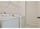 Laundry area with white washer, dryer, and shelf storage at 5661 Radford Loop, Fairburn, GA 30213