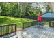 Relax on the spacious back deck with a red umbrella, overlooking a well-maintained yard with tall trees and a dark privacy fence at 4458 Trickum Ne Rd, Marietta, GA 30066