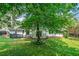Beautiful backyard featuring a lush green lawn, mature shade trees, and a patio, ideal for outdoor enjoyment and relaxation at 4458 Trickum Ne Rd, Marietta, GA 30066
