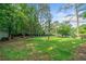 Expansive backyard with mature trees and lush green grass, offering ample space for recreation and privacy in a serene setting at 4458 Trickum Ne Rd, Marietta, GA 30066