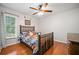 Cozy bedroom with hardwood floors, a ceiling fan, a window, and baseball themed decor at 4458 Trickum Ne Rd, Marietta, GA 30066