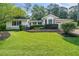 Charming home featuring a lush green lawn, mature landscaping, and a welcoming facade at 4458 Trickum Ne Rd, Marietta, GA 30066
