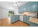 Bright kitchen with blue cabinets, granite counters, and a view of the outdoor patio at 4458 Trickum Ne Rd, Marietta, GA 30066