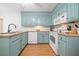 Functional kitchen featuring turquoise cabinets, granite countertops, and modern appliances at 4458 Trickum Ne Rd, Marietta, GA 30066