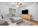 Comfortable living room with a large sectional sofa, media cabinet, ceiling fan and hardwood floors at 4458 Trickum Ne Rd, Marietta, GA 30066