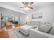 Spacious living room with hardwood floors, a ceiling fan, a large sectional sofa, and abundant natural light at 4458 Trickum Ne Rd, Marietta, GA 30066
