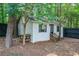 Cozy backyard shed with wooden steps surrounded by mature trees and a dark privacy fence, offering storage or workspace at 4458 Trickum Ne Rd, Marietta, GA 30066