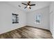 Bright bedroom featuring wood-look floors, a ceiling fan, and two windows providing ample natural light at 923 Smith Sw St, Atlanta, GA 30310