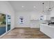 Bright, open kitchen area with white cabinets, quartz countertops, wood floors and glass door to the deck at 923 Smith Sw St, Atlanta, GA 30310