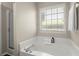 This bathroom features a tub next to a window and a glass enclosed shower at 2125 Mina Lane Dr, Buford, GA 30518