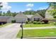 Charming home featuring a well-maintained lawn, mature landscaping, and a paved driveway at 2125 Mina Lane Dr, Buford, GA 30518