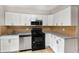 Bright kitchen featuring white cabinets, stainless steel appliances, and tile backsplash at 2340 Beaver Ruin Rd # 68, Norcross, GA 30071