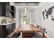 Dining area with wooden table, bench seating, modern light fixture, and dark cabinets at 2835 Channing Way, Cumming, GA 30040