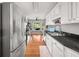 Galley kitchen featuring stainless steel appliances, white cabinets, and hardwood floors at 2835 Channing Way, Cumming, GA 30040
