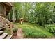 Green backyard features a play structure with slide and swings, set among lush landscaping, ideal for Gathering fun at 5107 Old Chestnut Ct, Woodstock, GA 30188