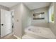 Neutral colored bathroom featuring a jacuzzi tub and a connecting bathroom at 5107 Old Chestnut Ct, Woodstock, GA 30188