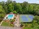 Aerial view of the community pool and tennis courts surrounded by lush trees at 5107 Old Chestnut Ct, Woodstock, GA 30188