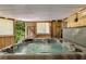 Luxurious hot tub with multicolor lights for a relaxing atmosphere, set within a screened-in and wood-paneled enclosure at 5107 Old Chestnut Ct, Woodstock, GA 30188