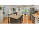 Spacious kitchen featuring granite countertops, stainless steel appliances, a central island, and hardwood floors at 5107 Old Chestnut Ct, Woodstock, GA 30188