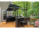 Outdoor kitchen with a grill, bar seating, and a pergola, perfect for entertaining at 5107 Old Chestnut Ct, Woodstock, GA 30188