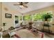 Bright sunroom with multiple windows, wicker furniture, and a ceiling fan at 5107 Old Chestnut Ct, Woodstock, GA 30188