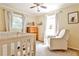 Warm Bedroom featuring a crib, cozy chair, and natural light from two windows at 1082 Greenbriar Cir, Decatur, GA 30033
