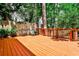 An exterior view of a stained wooden deck with chairs and table surrounded by a lush green landscape at 1082 Greenbriar Cir, Decatur, GA 30033