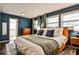 Bedroom with white bed linens, blue walls, three windows, and hardwood floors at 1082 Greenbriar Cir, Decatur, GA 30033