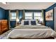 Bedroom with white bed linens, blue walls, three windows, and natural light at 1082 Greenbriar Cir, Decatur, GA 30033